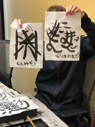 Student holding up his calligraphy work.