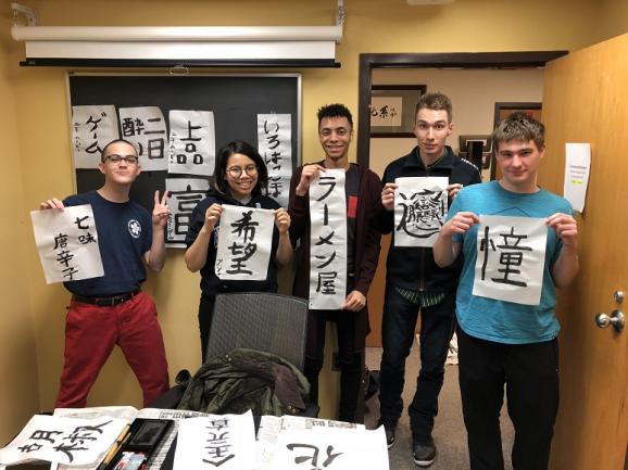 Group of students with their calligraphy work.