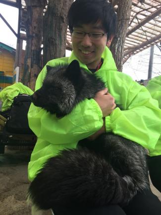 Kevin Yuan holding a black fox.