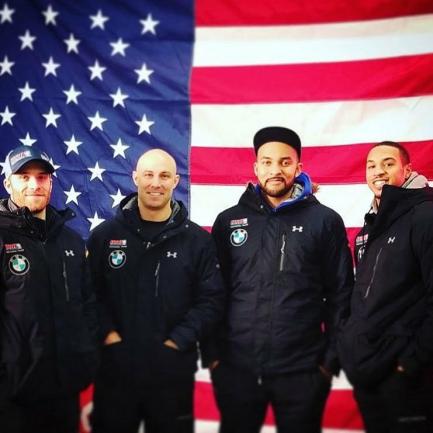 Christopher Kinney and others in front of an American flag.